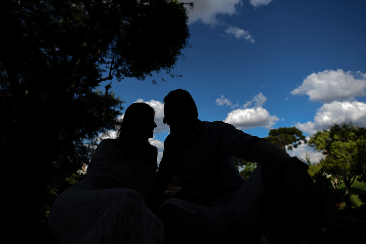 Ensaio de casal gestante em casa com cachorro fotografado pelo melhor fotógrafo de casamentos e ensaios de campo largo e Curitiba, Michel Druziki. Silhueta dos noivos com céu azul