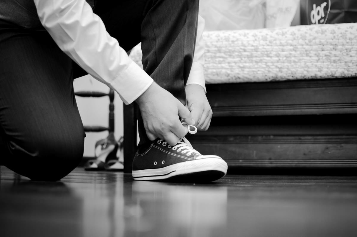 Casamento ao ar livre e de dia dos noivos Kelly e Flávio fotografado pelo melhor fotógrafo de Campo Largo e região de Curitiba, Michel Druziki. Noivo amarrando os sapatos, Noivo de all star