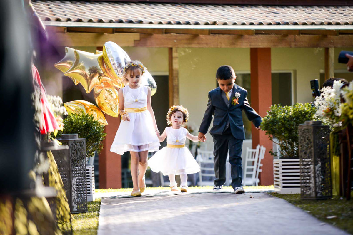 Casamento ao ar livre e de dia dos noivos Kelly e Flávio fotografado pelo melhor fotógrafo de Campo Largo e região de Curitiba, Michel Druziki. Daminhas e pagem com balões