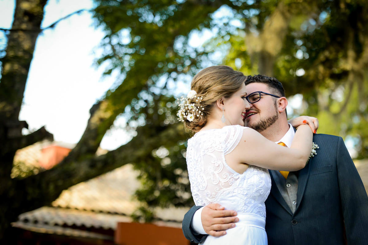 Casamento ao ar livre e de dia dos noivos Kelly e Flávio fotografado pelo melhor fotógrafo de Campo Largo e região de Curitiba, Michel Druziki. Noivos abraçados e sorrindo