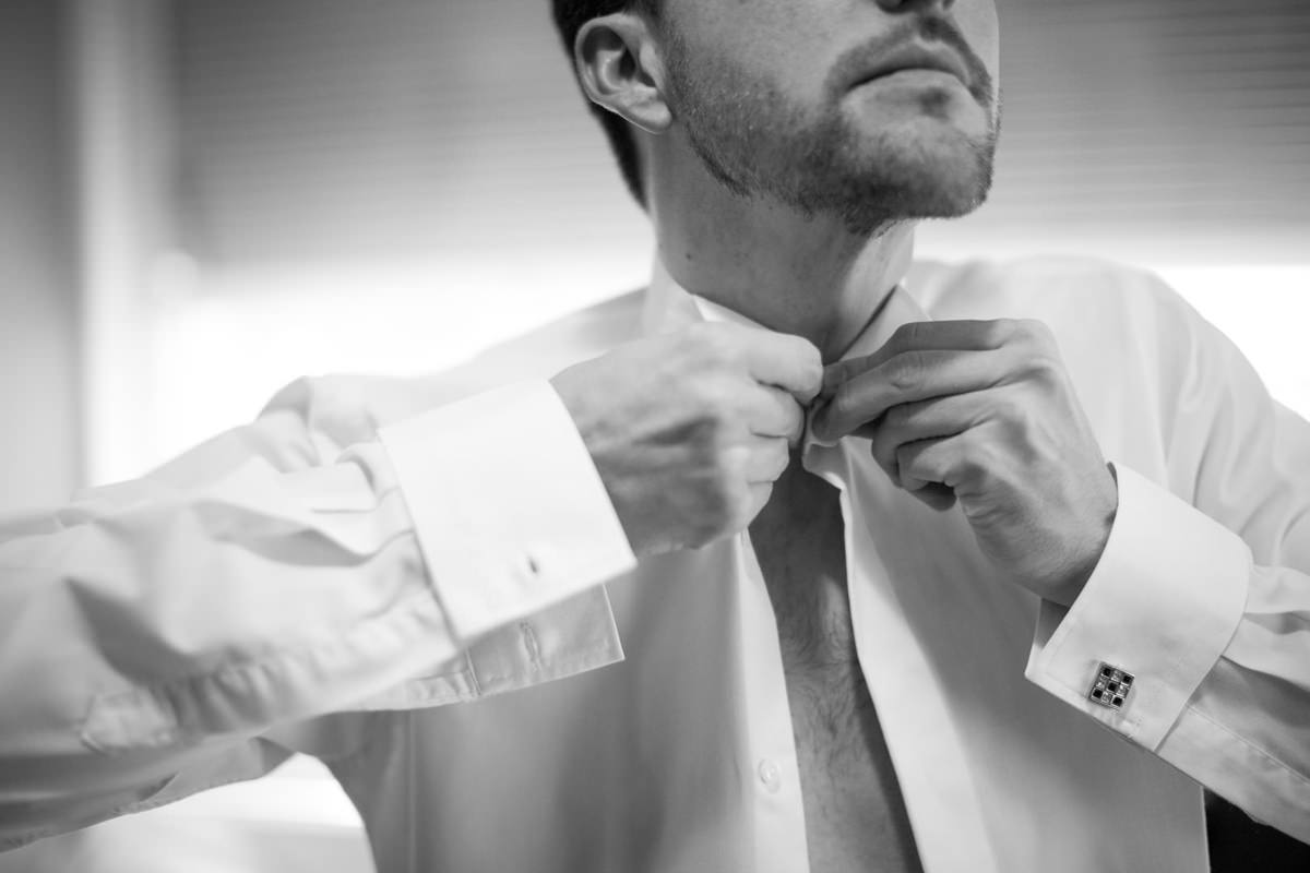 Casamento dos noivos Nayara e Emílio, fotografado pelo fotógrafo de ensaios e casamento em Campo Largo e Curitiba, Michel Druziki. Noivo fechando a camisa 