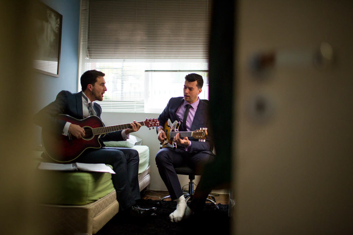 Casamento dos noivos Nayara e Emílio, fotografado pelo fotógrafo de ensaios e casamento em Campo Largo e Curitiba, Michel Druziki. Noivo e amigo tocando violão 