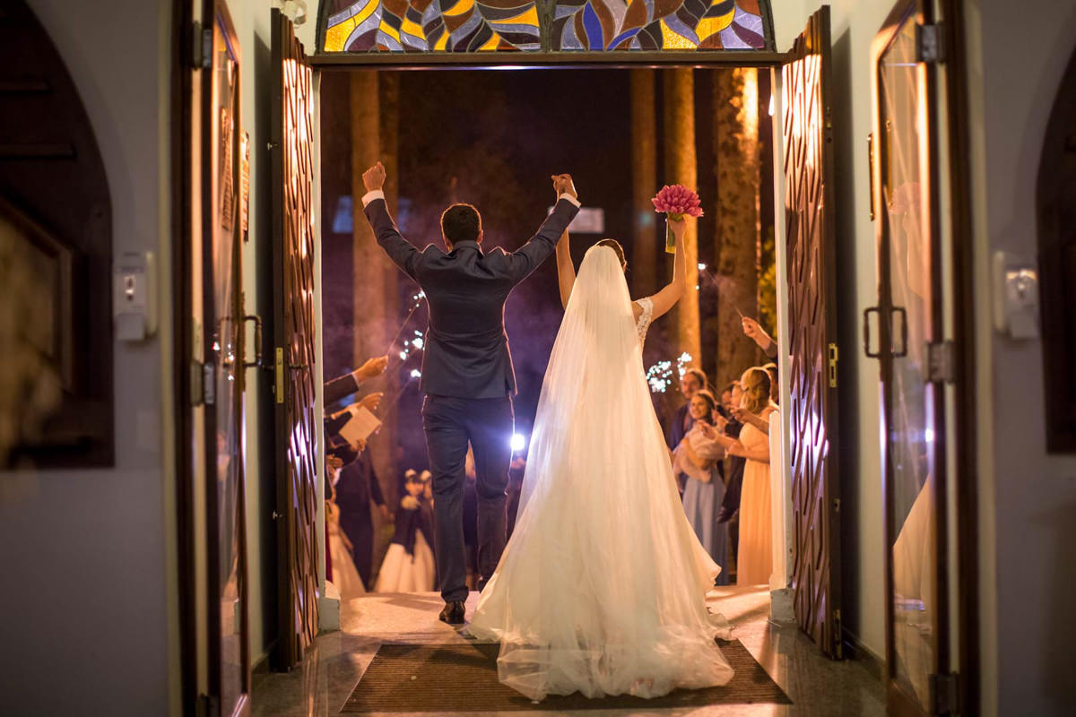 Casamento dos noivos Nayara e Emílio, fotografado pelo fotógrafo de ensaios e casamento em Campo Largo e Curitiba, Michel Druziki. Noivos comemorando na saída da igreja
