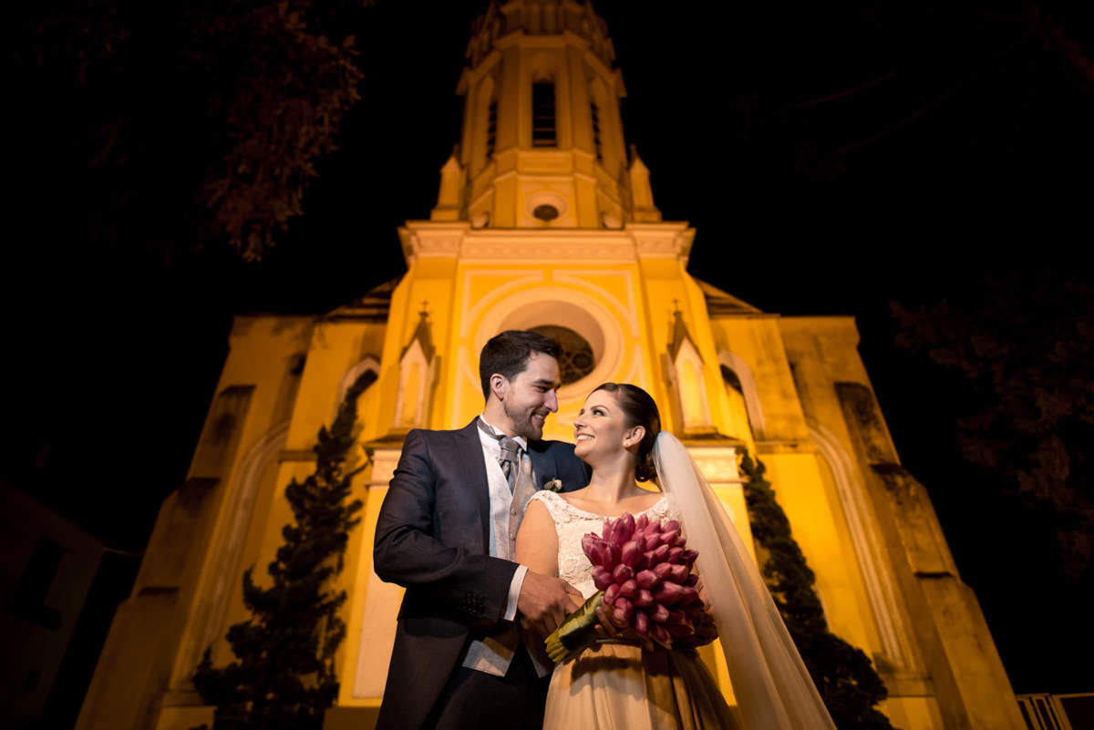 Casamento dos noivos Nayara e Emílio, fotografado pelo fotógrafo de ensaios e casamento em Campo Largo e Curitiba, Michel Druziki. Noivos sorrindo em frente à igreja depois do casamento