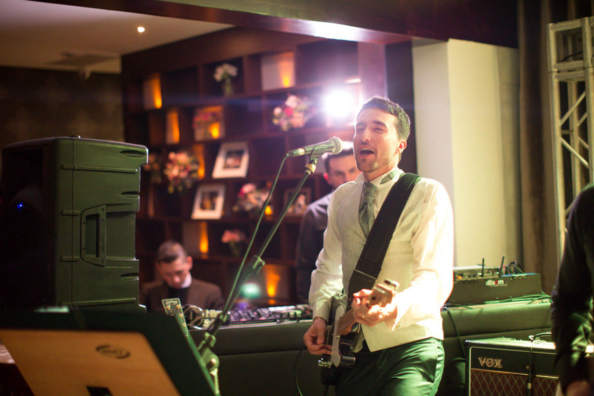 Casamento dos noivos Nayara e Emílio, fotografado pelo fotógrafo de ensaios e casamento em Campo Largo e Curitiba, Michel Druziki. Noivo cantando e tocando guitarra durante a festa