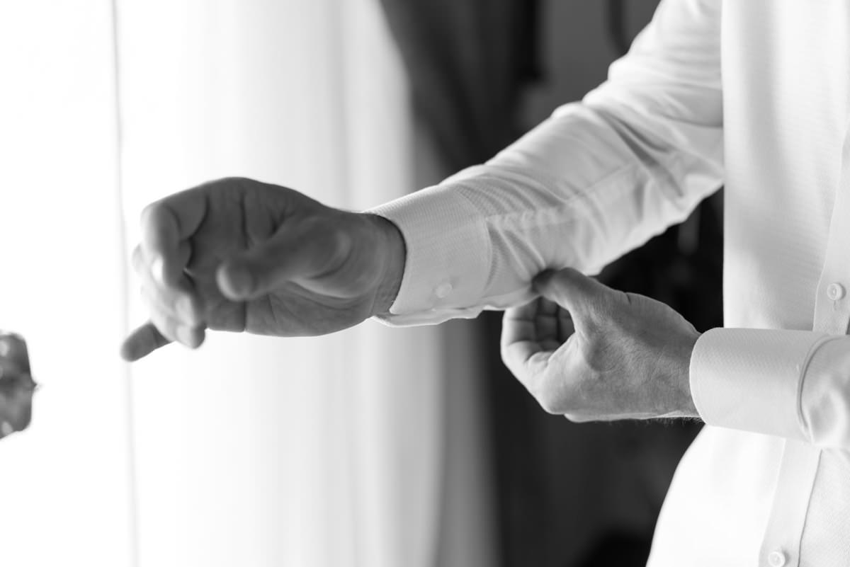 Casamento dos noivos Neriane e Eduardo fotografado pelo melhor fotógrafo de casamentos e ensaios de campo largo e Curitiba, Michel Druziki. Noivo abotoando a camisa