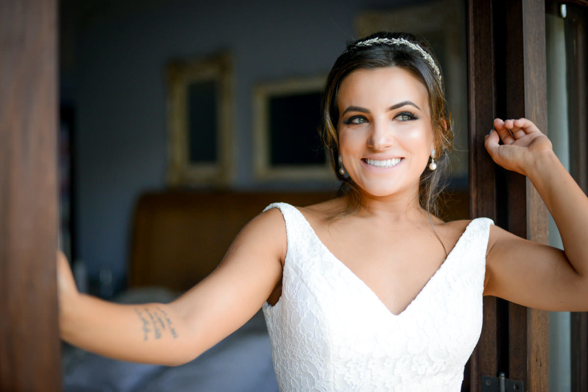 Casamento dos noivos Neriane e Eduardo fotografado pelo melhor fotógrafo de casamentos e ensaios de campo largo e Curitiba, Michel Druziki. Noiva sorrindo na janela