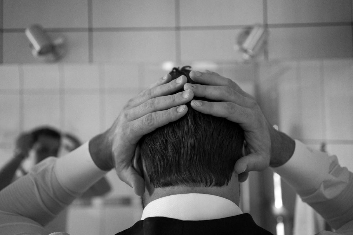 Casamento dos noivos Neriane e Eduardo fotografado pelo melhor fotógrafo de casamentos e ensaios de campo largo e Curitiba, Michel Druziki. Noivo arrumando o cabelo no espelho do banheiro