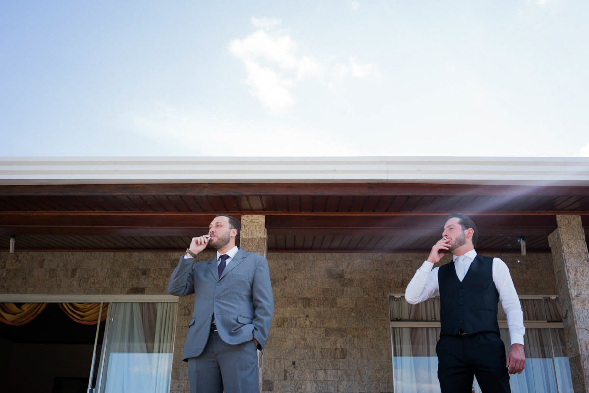 Casamento dos noivos Neriane e Eduardo fotografado pelo melhor fotógrafo de casamentos e ensaios de campo largo e Curitiba, Michel Druziki. Noivo fumando com amigo