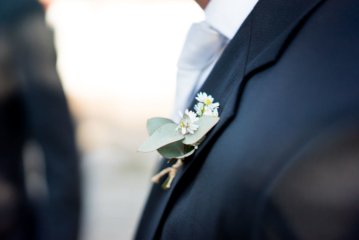 Casamento dos noivos Neriane e Eduardo fotografado pelo melhor fotógrafo de casamentos e ensaios de campo largo e Curitiba, Michel Druziki. Detalhe das flores no paletó do noivo