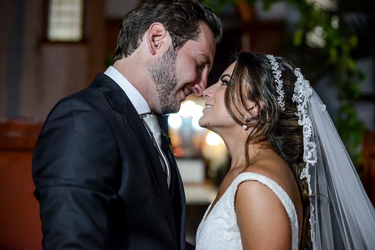 Casamento dos noivos Neriane e Eduardo fotografado pelo melhor fotógrafo de casamentos e ensaios de campo largo e Curitiba, Michel Druziki. Noivos com nariz encostados em frente à igreja