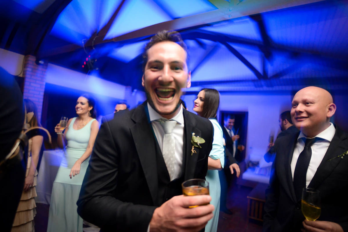 Casamento dos noivos Neriane e Eduardo fotografado pelo melhor fotógrafo de casamentos e ensaios de campo largo e Curitiba, Michel Druziki. Noivo com copo de whisky sorrindo durante a festa
