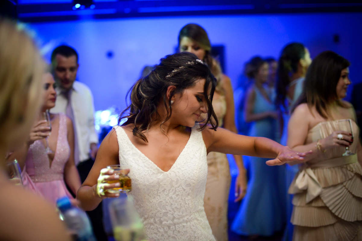 Casamento dos noivos Neriane e Eduardo fotografado pelo melhor fotógrafo de casamentos e ensaios de campo largo e Curitiba, Michel Druziki. Noiva dançando com copo de whisky na mão
