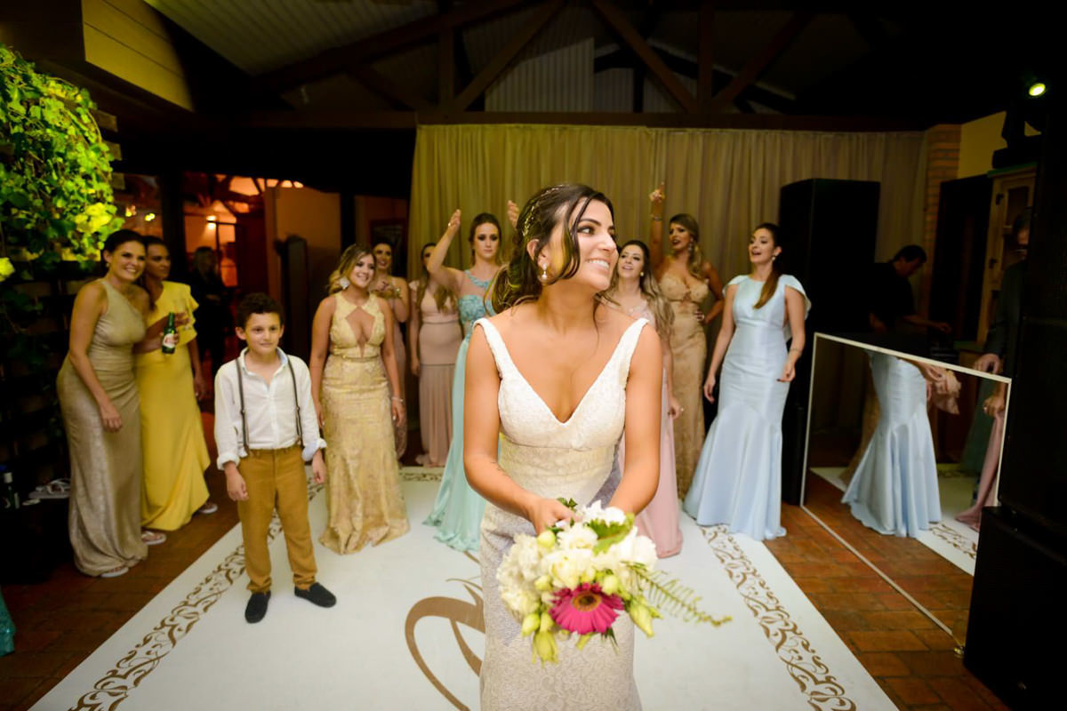 Casamento dos noivos Neriane e Eduardo fotografado pelo melhor fotógrafo de casamentos e ensaios de campo largo e Curitiba, Michel Druziki. Noiva jogando o buquê