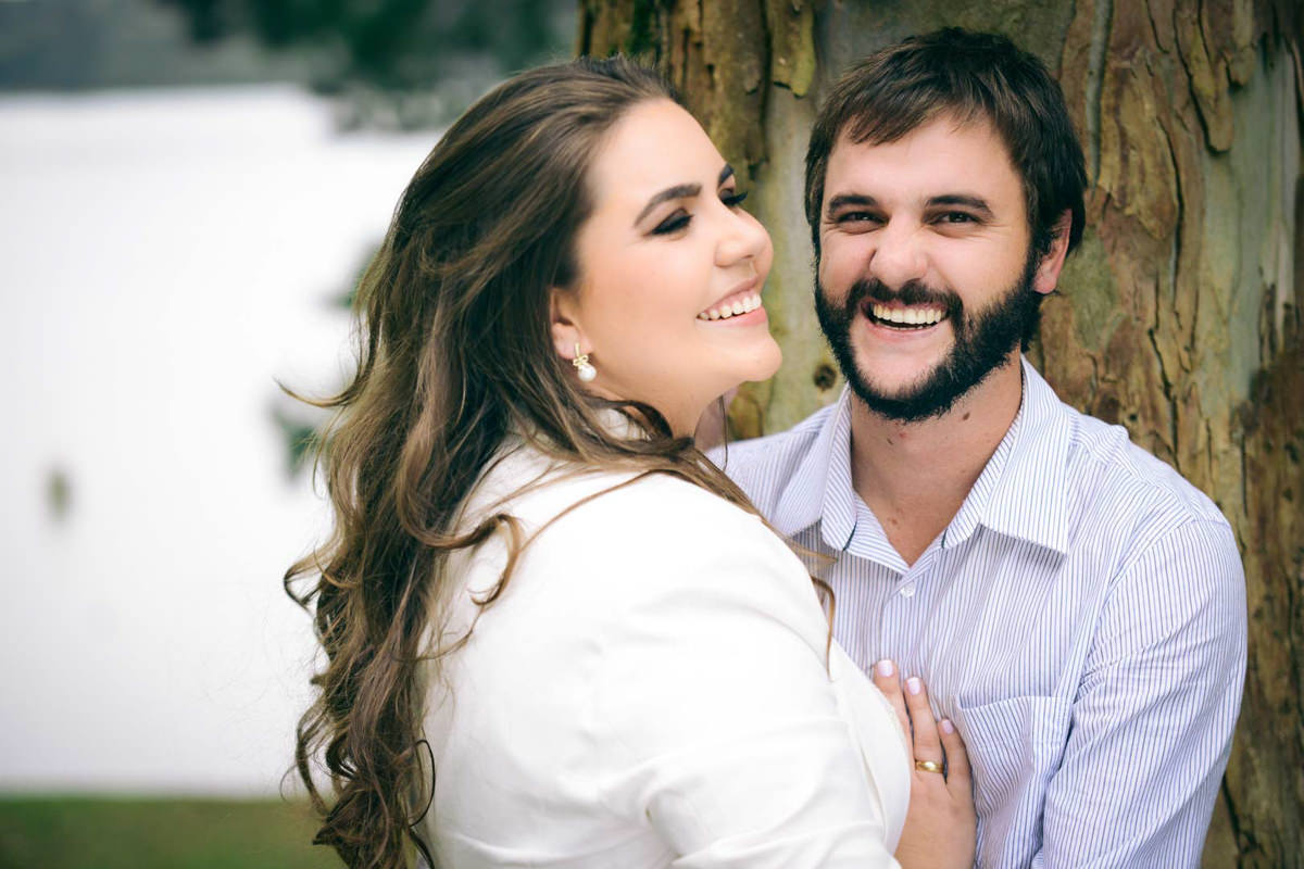 Pre wedding no campo do casal Nicole e Alisson fotografado pelo melhor fotógrafo de casamentos de campo largo e Curitiba, Michel Druziki. Noivos sorrindo encostados na árvore.