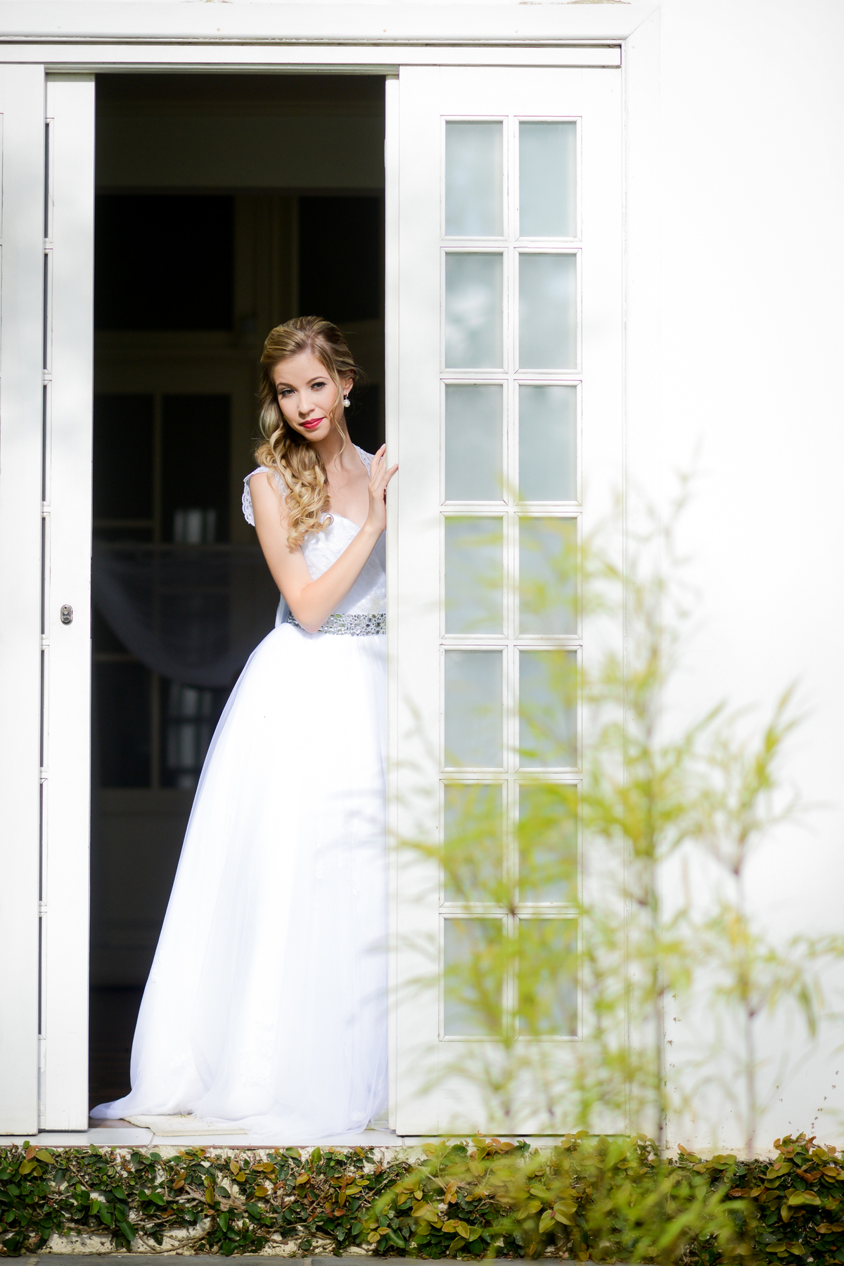 Casamento ao ar livre e de dia dos noivos Roxanne e Diego fotografado pelo melhor fotógrafo de Campo Largo e região de Curitiba, Michel Druziki. Noiva na porta janela 