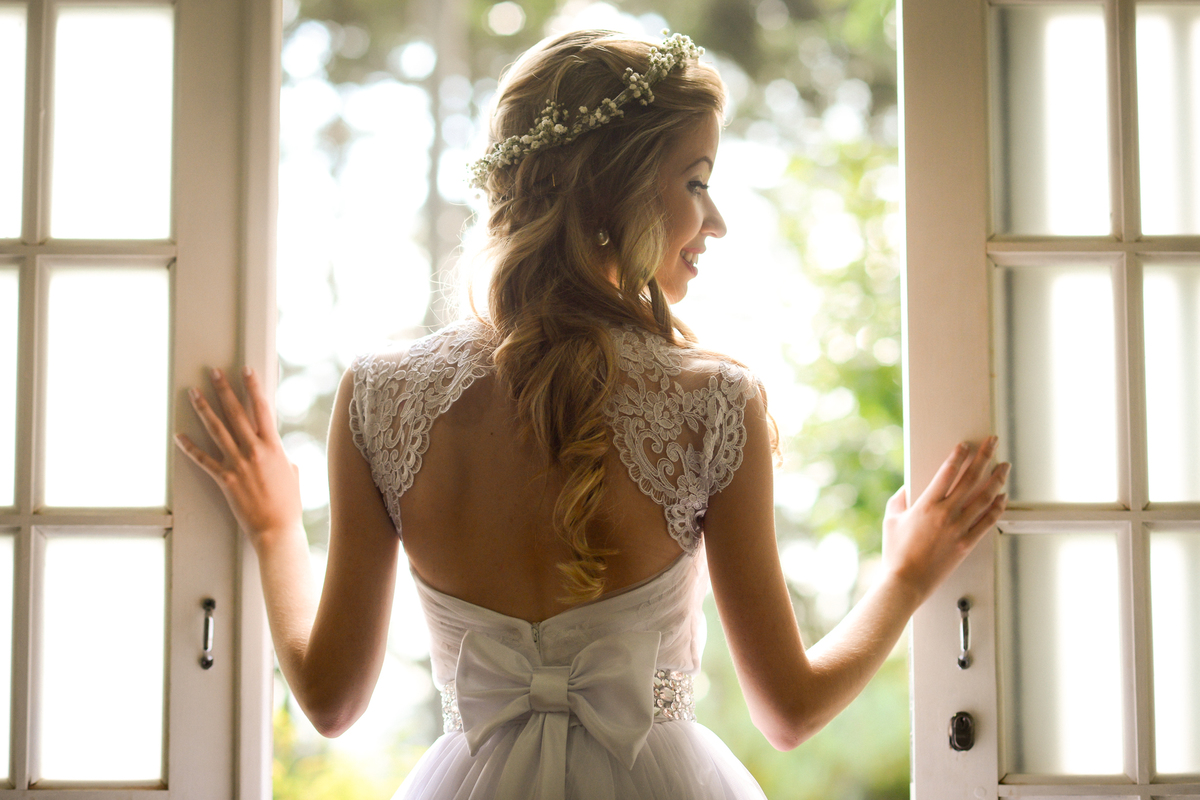 Casamento ao ar livre e de dia dos noivos Roxanne e Diego fotografado pelo melhor fotógrafo de Campo Largo e região de Curitiba, Michel Druziki. Contra luz 
 da noiva na porta janela