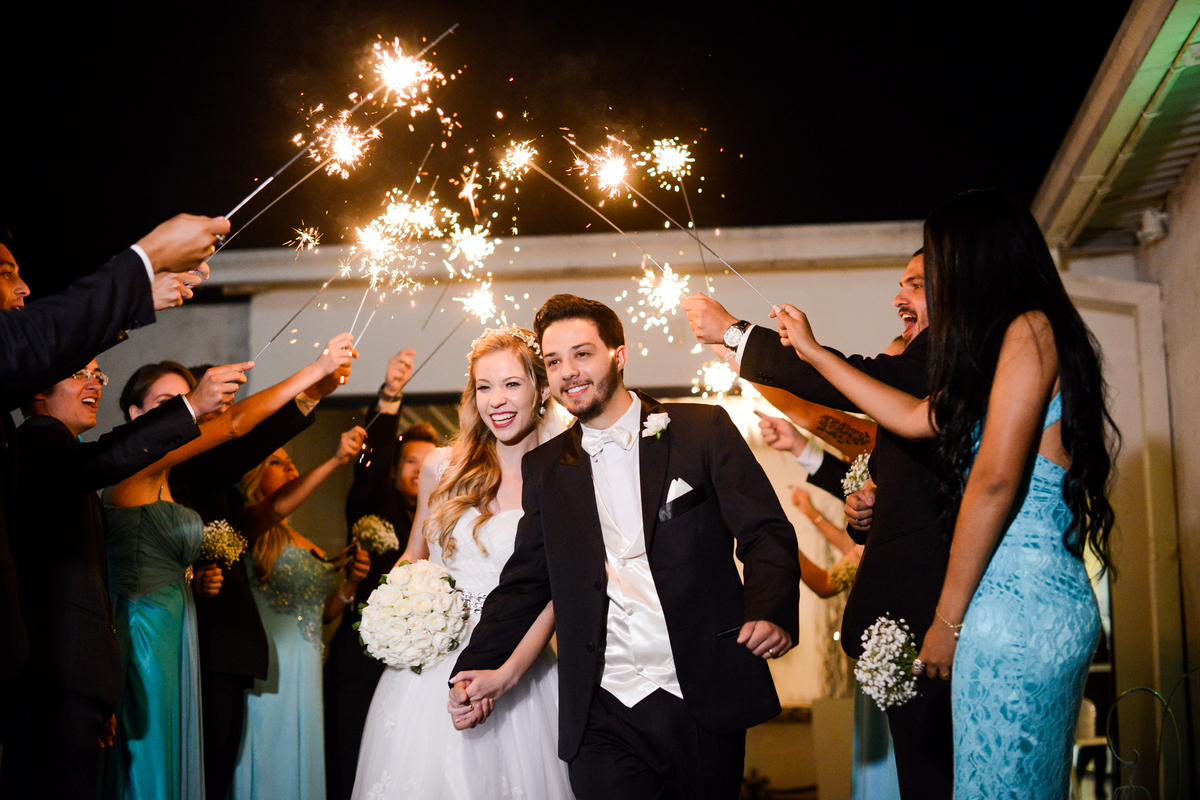 Casamento dos noivos Roxanne e Diego fotografado pelo melhor fotógrafo de Campo Largo e região de Curitiba, Michel Druziki. Saída dos noivos com túnel de convidados e velas estrelas de prata
