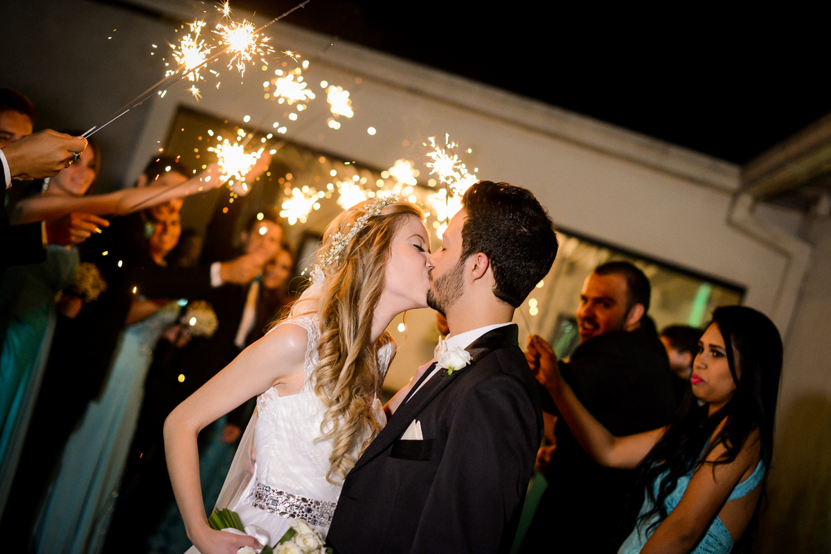 Casamento dos noivos Roxanne e Diego fotografado pelo melhor fotógrafo de Campo Largo e região de Curitiba, Michel Druziki. Noivos se beijando e convidados com vela estrela de prata