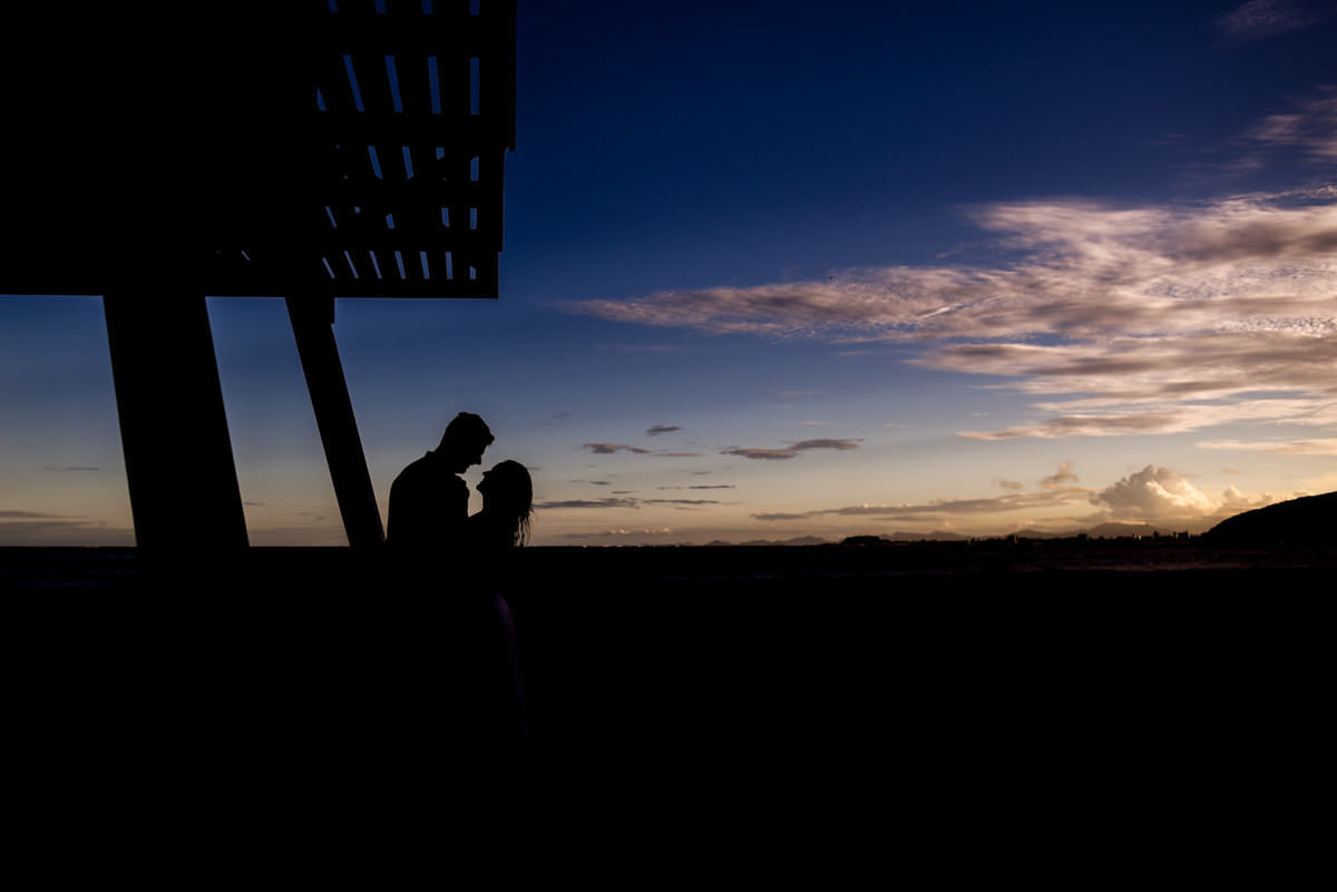 Ensaio pre-wedding dos noivos Vanessa e Adriano. Fotografados por um dos melhores fotógrafos de casamento do Brasil, Michel Druziki. O ensaio foi realizado na praia. Silhueta dos noivos abraçados no fim da tarde na praia