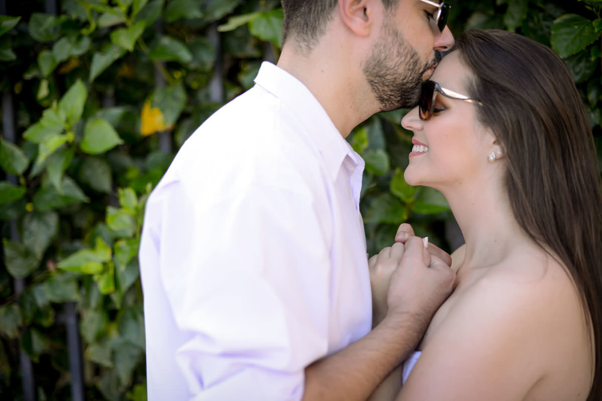 Ensaio pre-wedding dos noivos Vanessa e Adriano. Fotografados por um dos melhores fotógrafos de casamento do Brasil, Michel Druziki. O ensaio foi realizado na praia. Noivo beijando a testa da noiva em frente a parede verde
