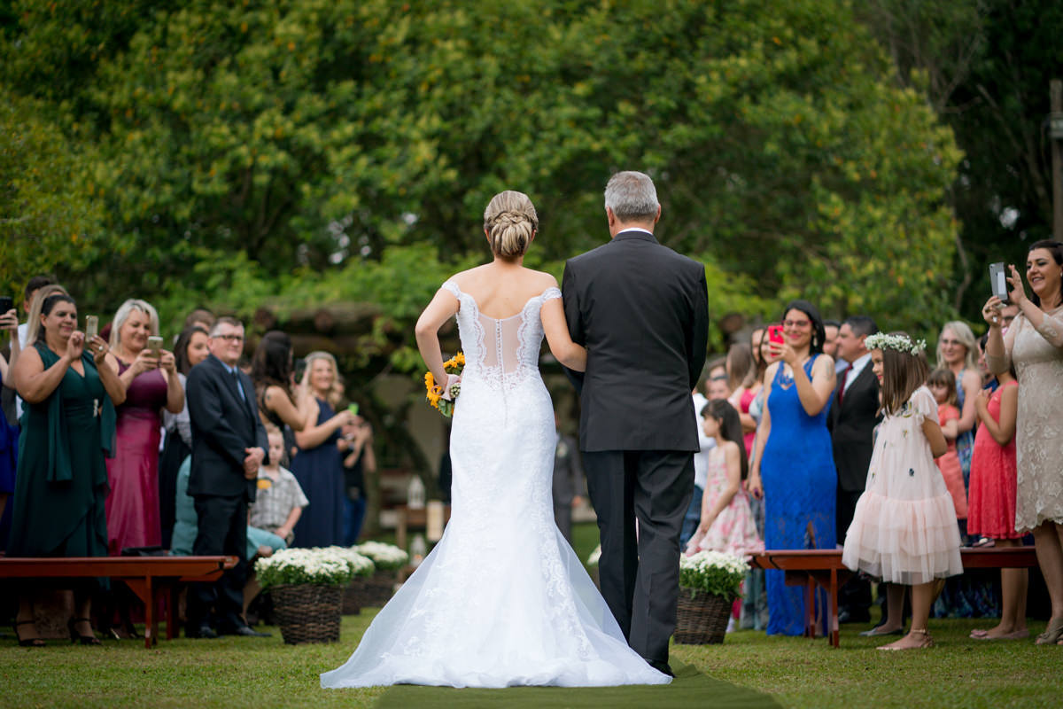 Casamento dos noivos Debora e Felipe realizado no negrão eventos, em Balsa Nova - PR, na região de Curitiba e fotografado pelo fotógrafo de casamentos Michel Druziki. Noiva acompanhada do pai chegando para a cerimônia