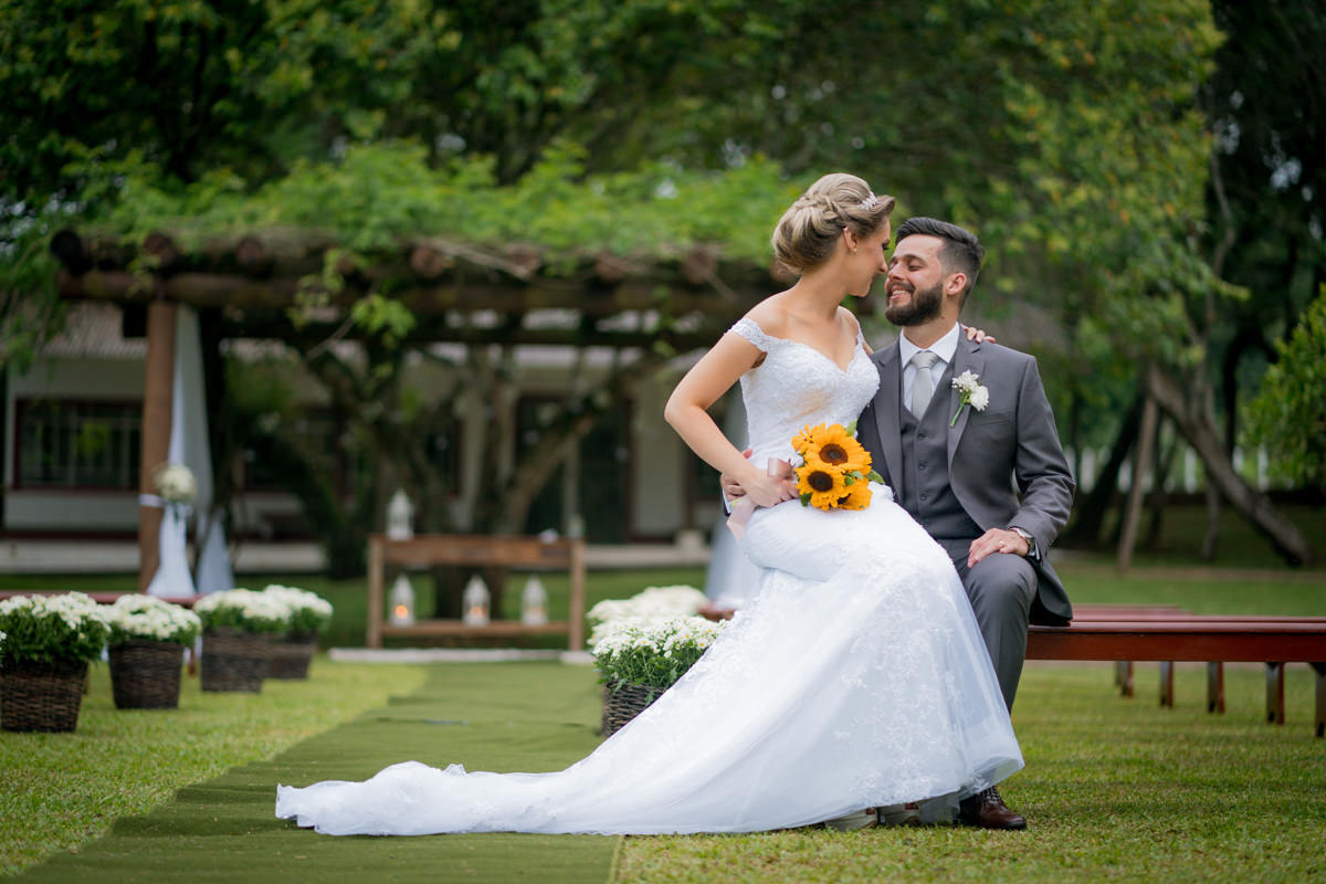 Casamento dos noivos Debora e Felipe realizado no negrão eventos, em Balsa Nova - PR, na região de Curitiba e fotografado pelo fotógrafo de casamentos Michel Druziki. Noivos sentados ao ar livre depois do casamento
