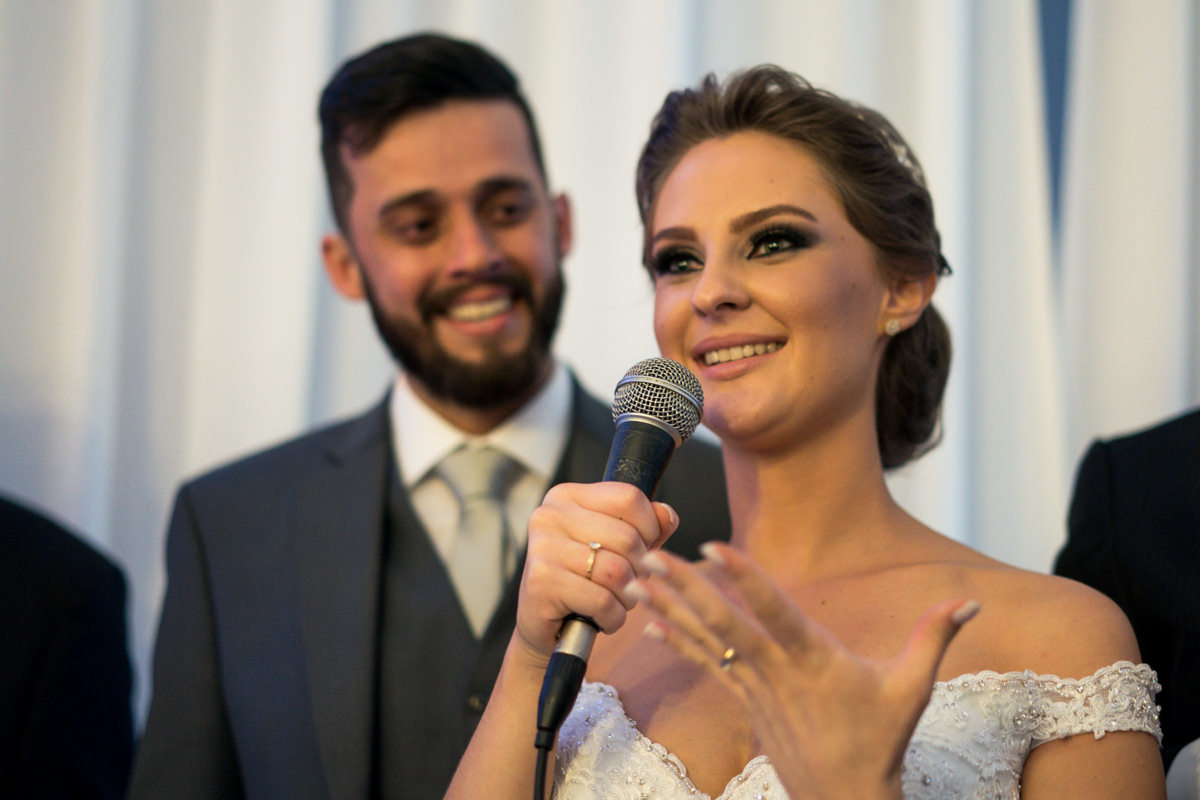 Casamento dos noivos Debora e Felipe realizado no negrão eventos, em Balsa Nova - PR, na região de Curitiba e fotografado pelo fotógrafo de casamentos Michel Druziki. Noiva discursando e noivo olhando apaixonado