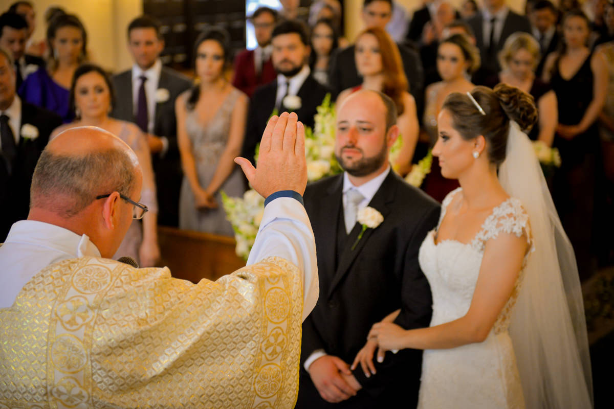 Casamento dos queridos Larissa e Cícero fotografado pelo melhor fotógrafo de casamentos de campo largo e Curitiba, Michel Druziki. Padre dando a bênção ao casal
