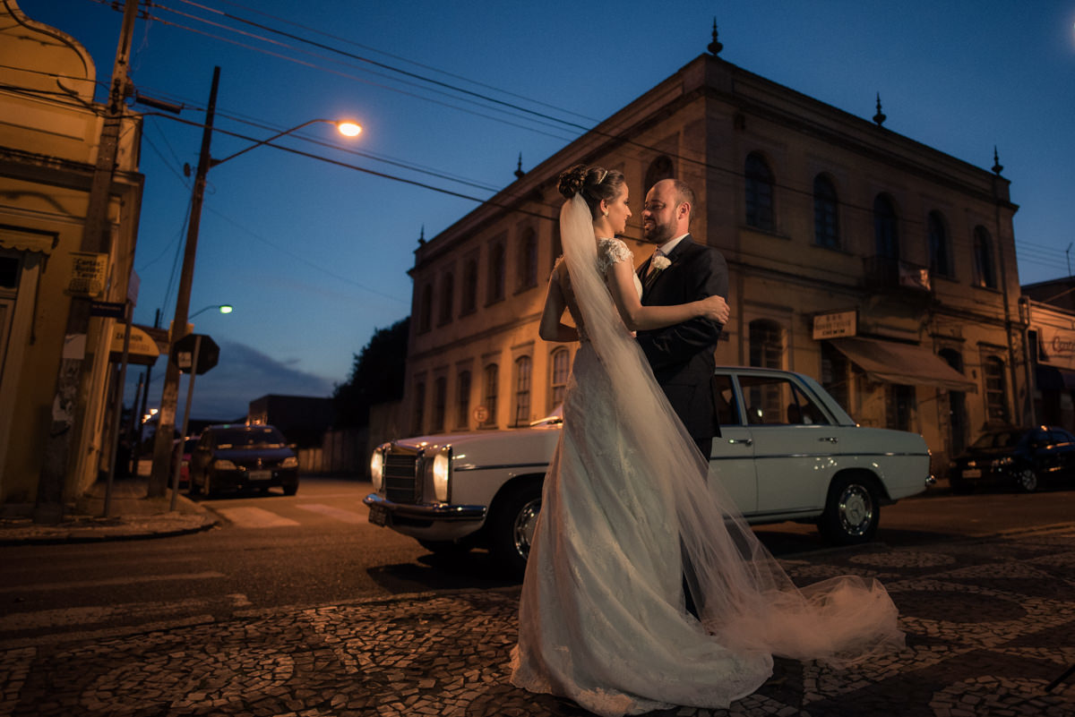 Casamento dos queridos Larissa e Cícero fotografado pelo melhor fotógrafo de casamentos de campo largo e Curitiba, Michel Druziki. Noivos abraçados e sorrindo na rua depois do casamento, céu azul