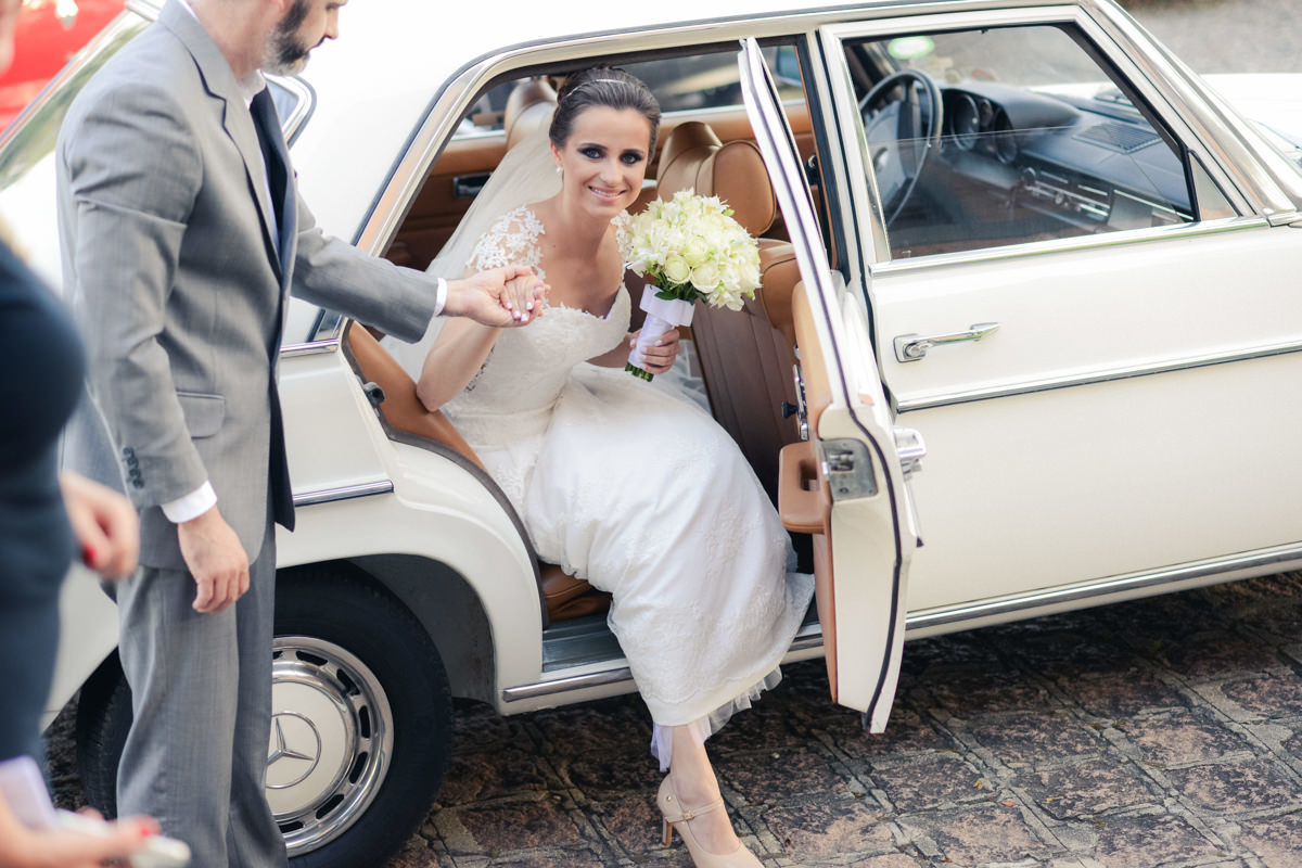 Casamento dos queridos Larissa e Cícero fotografado pelo melhor fotógrafo de casamentos de campo largo e Curitiba, Michel Druziki. Noiva descendo do carro em frente à igreja