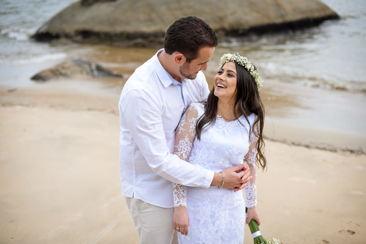 Ensaio de casamento na praia dos noivos Bruna e Jefferson fotografado pelo fotógrafo de Campo Largo e Curitiba, Michel Druziki. Noivos abraçados e sorrindo na areia