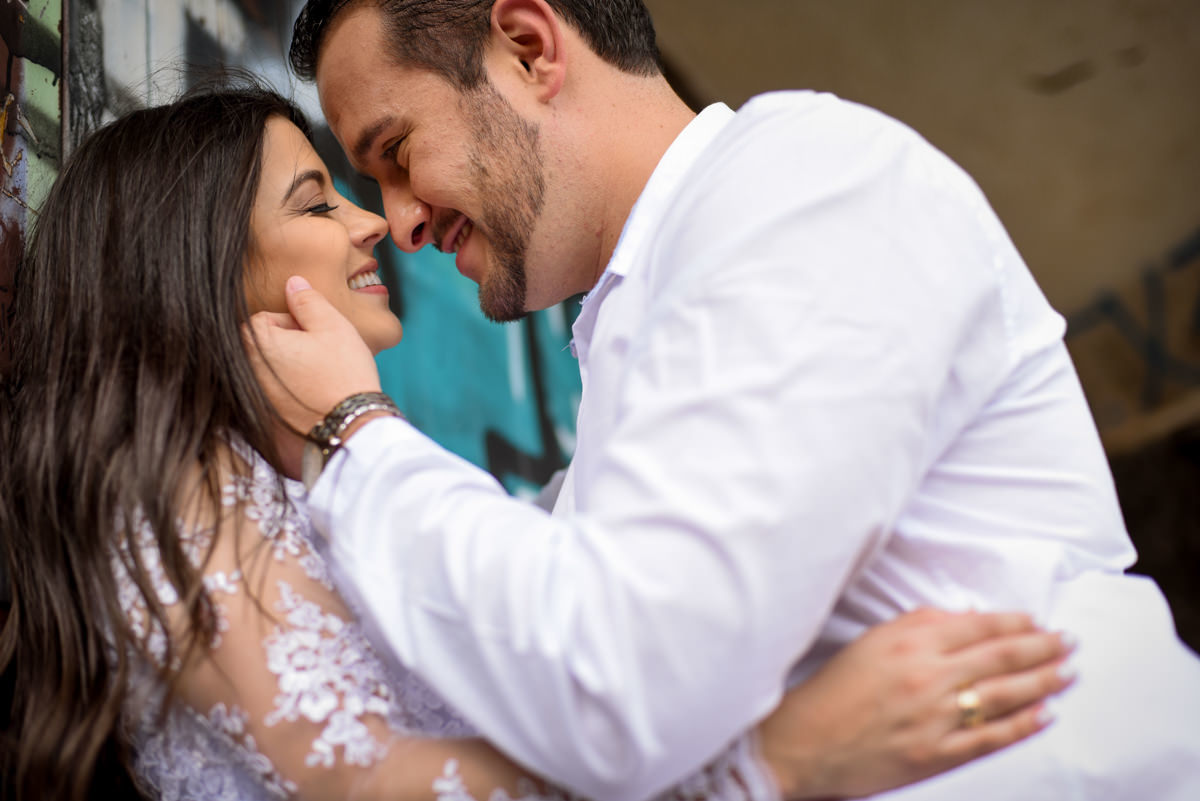 Ensaio de casamento na praia dos noivos Bruna e Jefferson fotografado pelo fotógrafo de Campo Largo e Curitiba, Michel Druziki. Noiva de olhos fechados sorrindo e noivo olhando