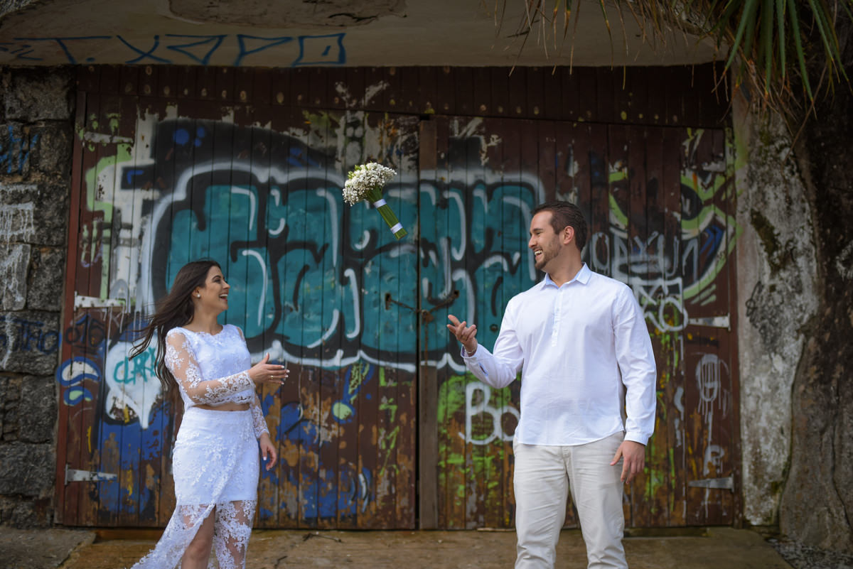 Ensaio de casamento na praia dos noivos Bruna e Jefferson fotografado pelo fotógrafo de Campo Largo e Curitiba, Michel Druziki. Noiva jogando o buquê para o noivo