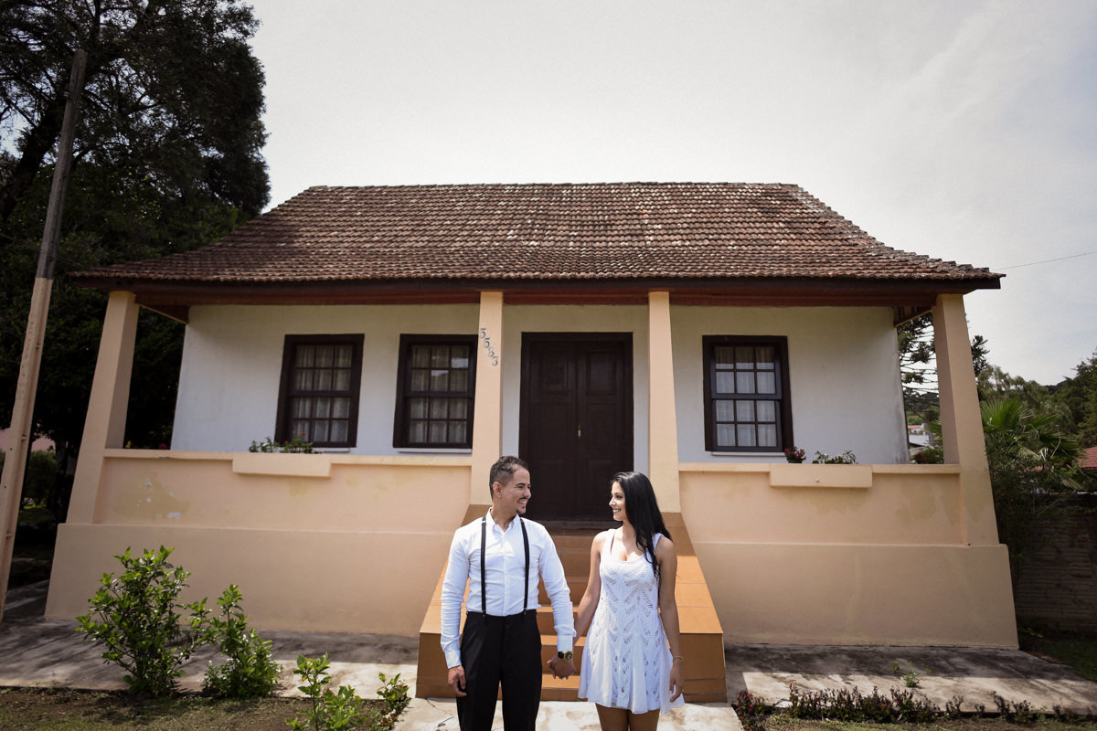 Ensaio do casal Letícia e Rodrigo em casa fotografado pelo melhor fotógrafo de casamentos e ensaios de campo largo e Curitiba, Michel Druziki. Noivos de mãos dadas em frente à casa