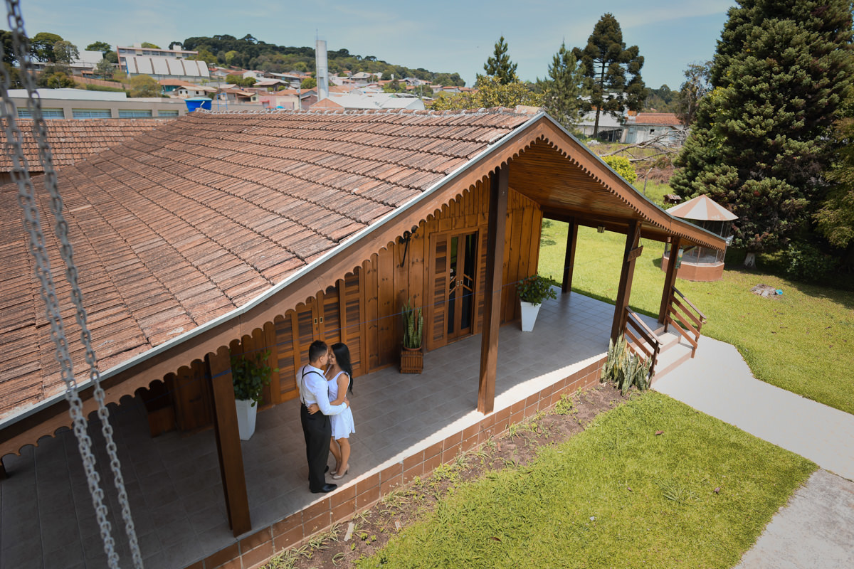 Ensaio do casal Letícia e Rodrigo em casa fotografado pelo melhor fotógrafo de casamentos e ensaios de campo largo e Curitiba, Michel Druziki. Casal abraçado na varanda da casa