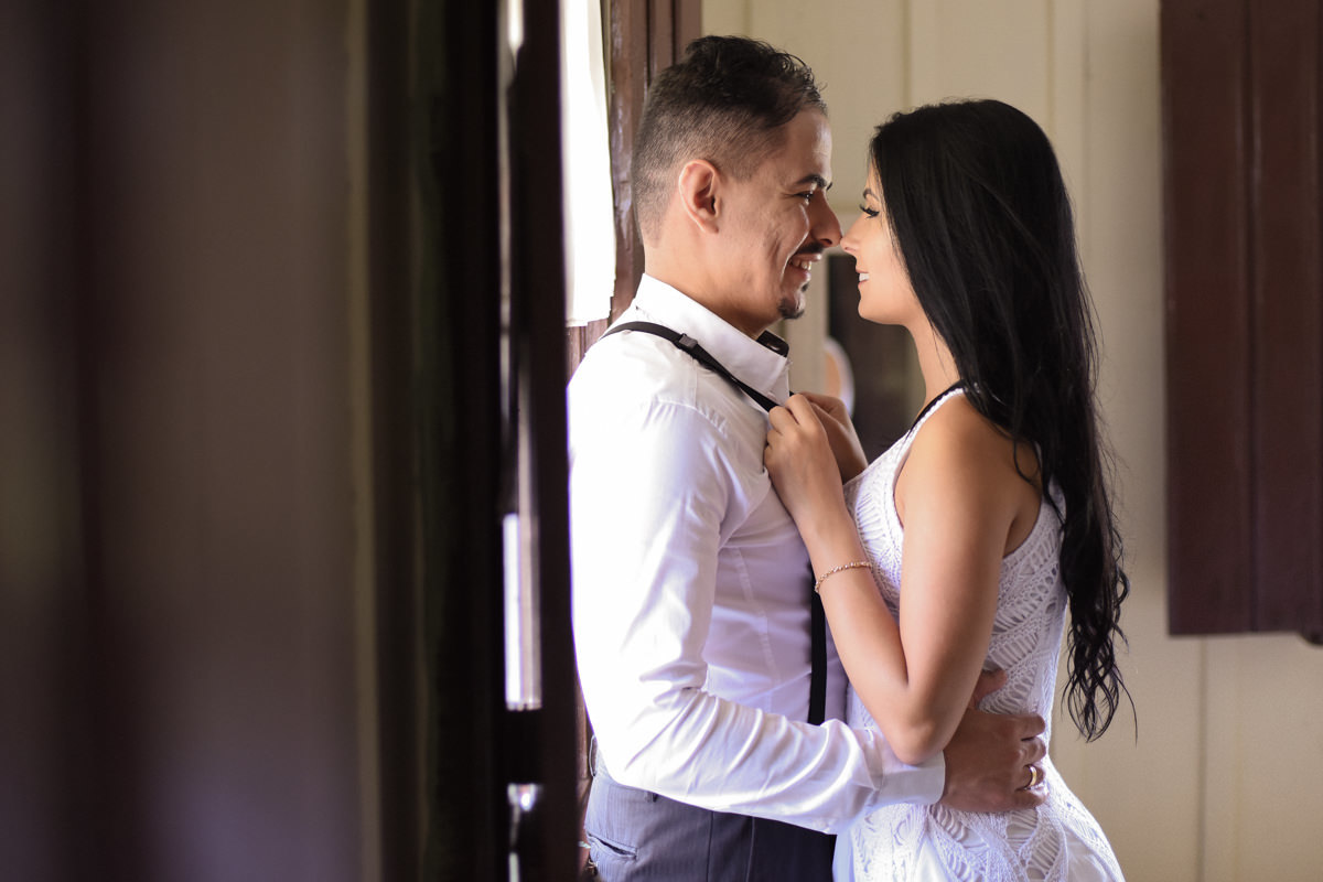 Ensaio do casal Letícia e Rodrigo em casa fotografado pelo melhor fotógrafo de casamentos e ensaios de campo largo e Curitiba, Michel Druziki. Noivos sorrindo encostados na janela