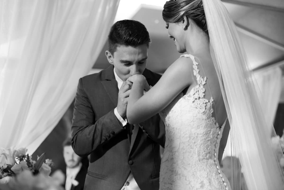 O fotógrafo de casamentos Michel Druziki, fotografou o casamento sofisticado e lindo do casal Thamis e Alexandre, em um sábado na cidade de Curitiba. O noivo beijando a aliança da noiva