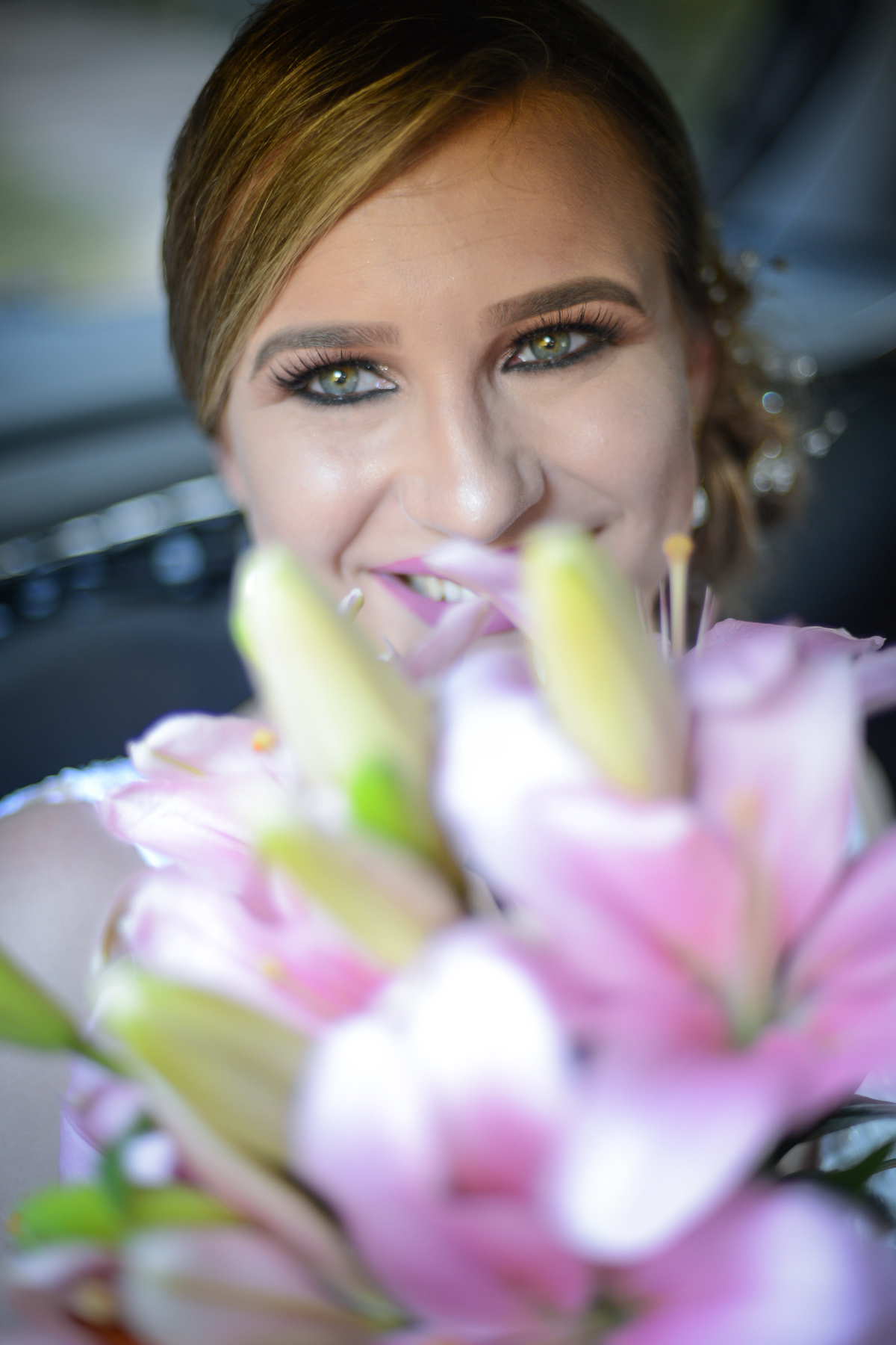 Casamento de dia ao ar livre dos noivos Cheila e Lúcio, no Negrão Eventos, fotografado pelo melhor fotógrafo de casamentos de campo largo e Curitiba, Michel Druziki. Noiva sorrindo com buquê de lírios 