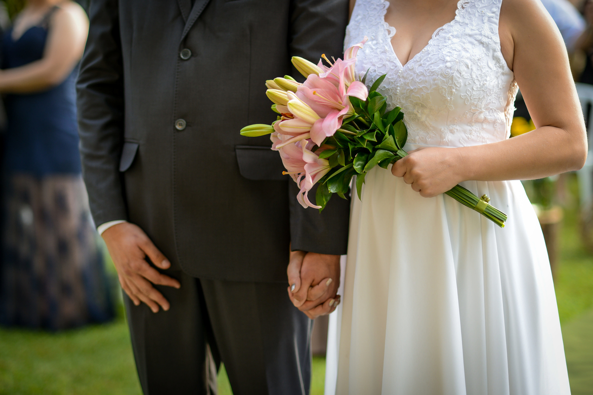 Casamento de dia ao ar livre dos noivos Cheila e Lúcio, no Negrão Eventos, fotografado pelo melhor fotógrafo de casamentos de campo largo e Curitiba, Michel Druziki. Noivos de mãos dadas durante a cerimônia