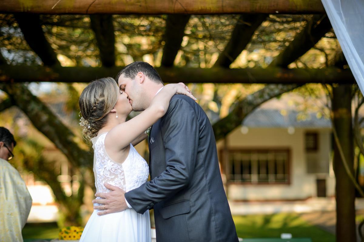 Casamento de dia ao ar livre dos noivos Cheila e Lúcio, no Negrão Eventos, fotografado pelo melhor fotógrafo de casamentos de campo largo e Curitiba, Michel Druziki. Noivos se beijando