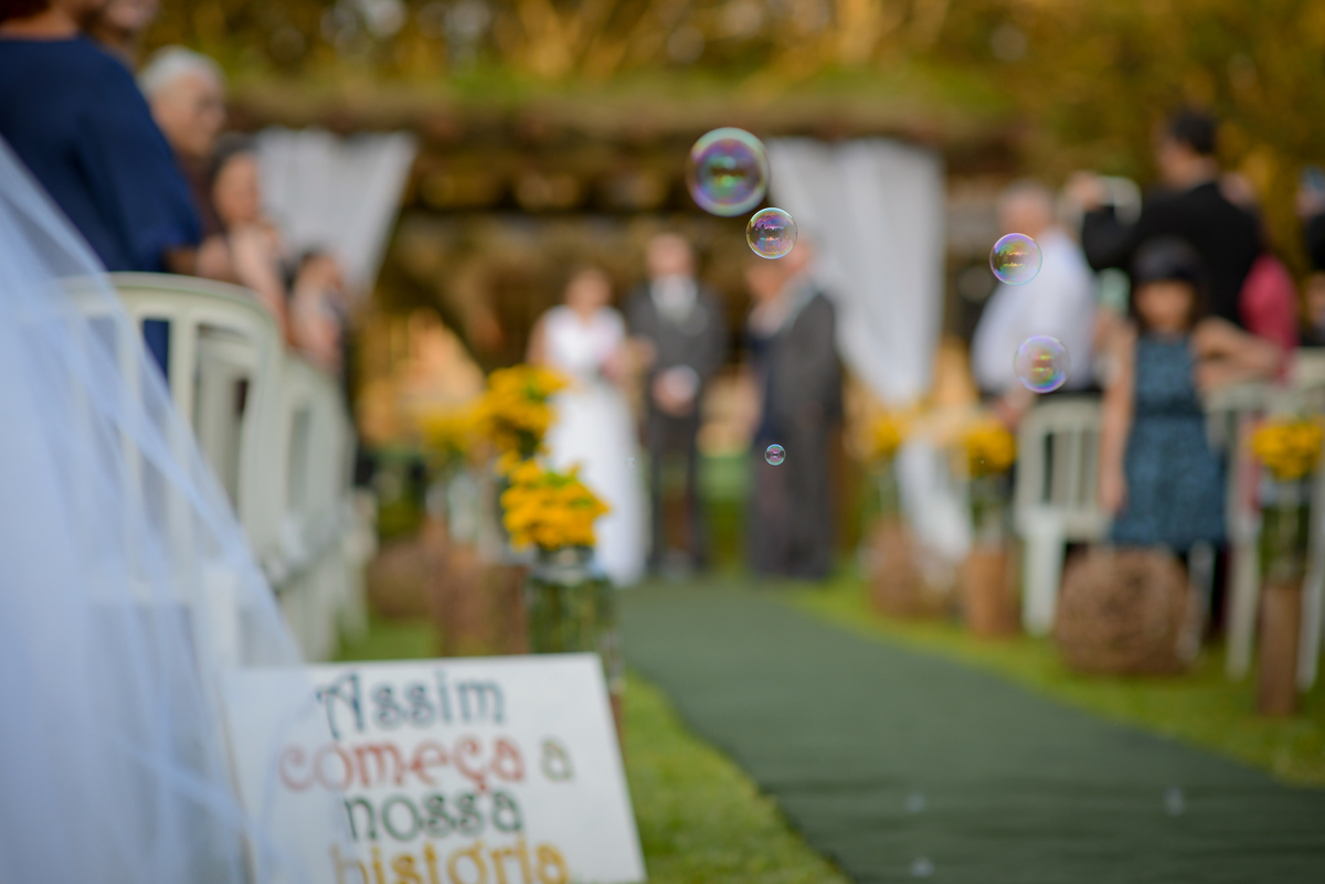 Casamento de dia ao ar livre dos noivos Cheila e Lúcio, no Negrão Eventos, fotografado pelo melhor fotógrafo de casamentos de campo largo e Curitiba, Michel Druziki. Saída dos noivos com bolinhas de sabão