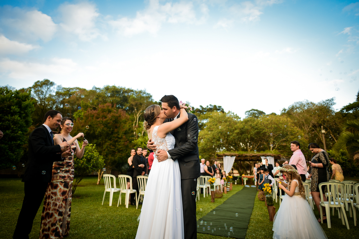 Casamento de dia ao ar livre dos noivos Cheila e Lúcio, no Negrão Eventos, fotografado pelo melhor fotógrafo de casamentos de campo largo e Curitiba, Michel Druziki. Noivos se beijando 