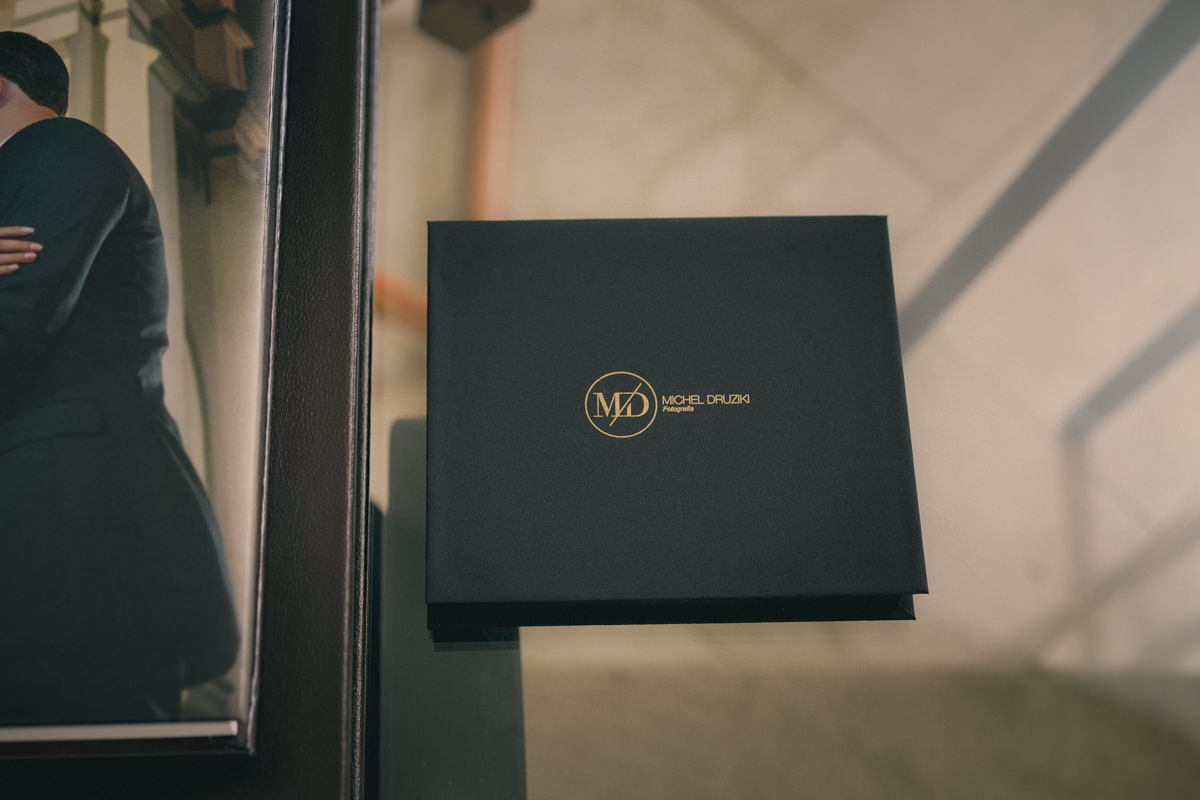 O álbum de casamento da Raphaela e do Murilo, teve uma caixa em couro legítimo, com os nomes gravados em baixo relevo. Na parte interna, uma bolsa em revestimento soft-touch, capa e contra-capa em papel fotográfico canvas e interior em papel seda. 
