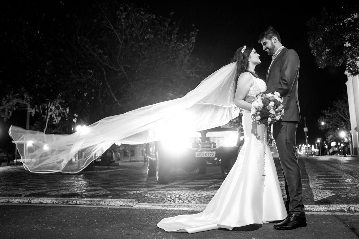 O fotógrafo de casamentos Michel Druziki, fotografou o casamento lindo do casal Gisele e Vinícius na cidade de Campo Largo. Noivos abraçados depois da cerimônia, véu da noiva voando