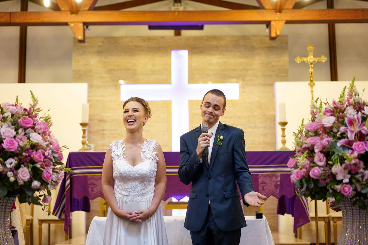 Casamento dos noivos Francine e Rodrigo realizado em Curitiba, com festa no restaurante Madalosso, fotografado pelo melhor fotógrafo de casamentos de Campo Largo e Curitiba, Michel Druziki. Noivos dando risada ao falar com os convidados no microfone