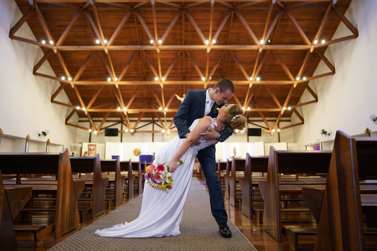 Casamento dos noivos Francine e Rodrigo realizado em Curitiba, com festa no restaurante Madalosso, fotografado pelo melhor fotógrafo de casamentos de Campo Largo e Curitiba, Michel Druziki. Noivo segurando a noiva antes do beijo dentro da igreja