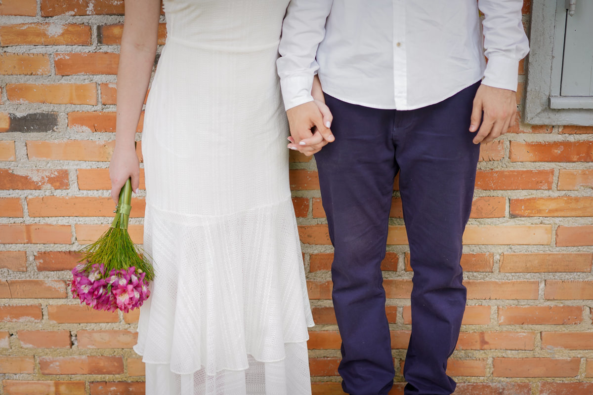 Ensaio de casamento do casal Camila e Guto fotografado pelo fotógrafo Michel Druziki em Campo Largo. Noivos de mãos dadas encostados na parede