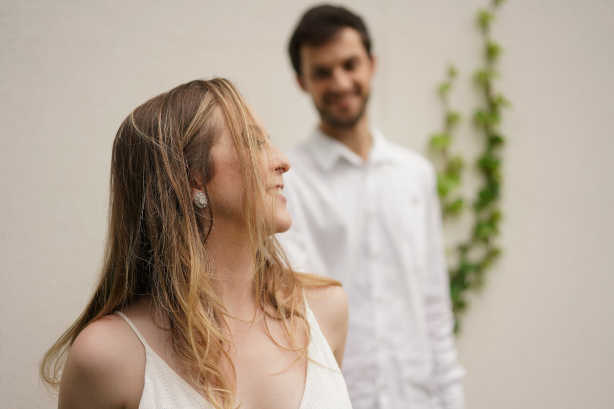 Ensaio de casamento do casal Camila e Guto fotografado pelo fotógrafo Michel Druziki em Campo Largo. Noiva sorrindo no primeiro plano e noivo desfocado