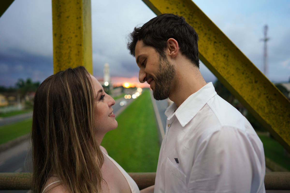 Ensaio de casamento do casal Camila e Guto fotografado pelo fotógrafo Michel Druziki em Campo Largo. Casal em cima da passarela se olhando e sorrindo